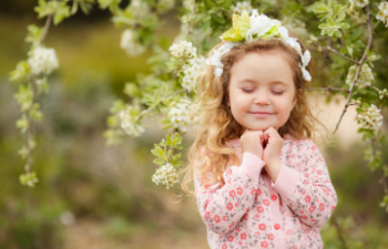 happy calm little blonde girl in pink sweater